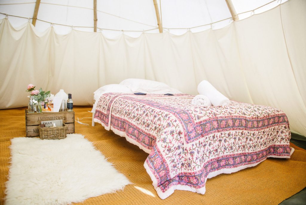 Majestic tipi for two with pink quilt at Pennard Orchard boutique Camping for Glastonbury Festival